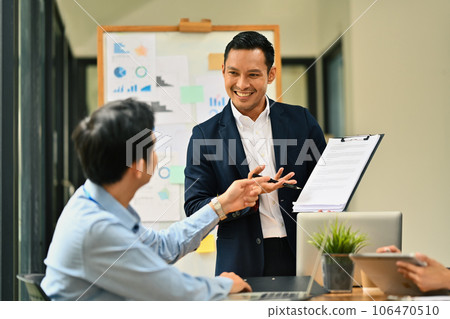 Friendly male manager explaining project details, talking about business to his colleague at meeting 106470510