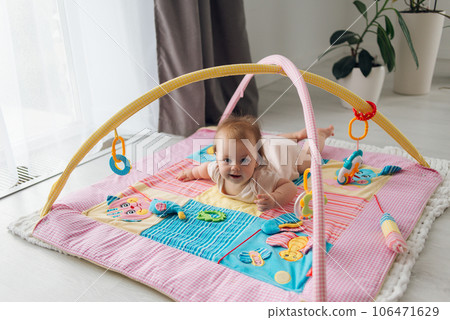 Cute satisfied child lying on a bright children's educational mat. High quality photo Cute satisfied child lying on a bright children's educational mat. High quality photo 106471629