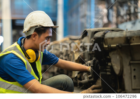 Engineer male worker check inventory store old used auto spare part engine gear part list for sale recycle in repair car garage market 106472296