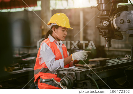 woman worker hard work focus working in heavy metal machine lathe milling factory industry woman worker hard work focus working in heavy metal machine lathe milling factory industry 106472302