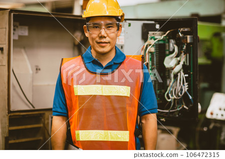 Portrait electrician male worker. electricity engineer man at high voltage circuit cabinet. technician at circuit breaker power line control room. 106472315