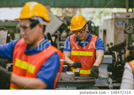 Asian expert technician engineer male focus detail working precision manual cut lathe milling metal production in heavy industry 106472318