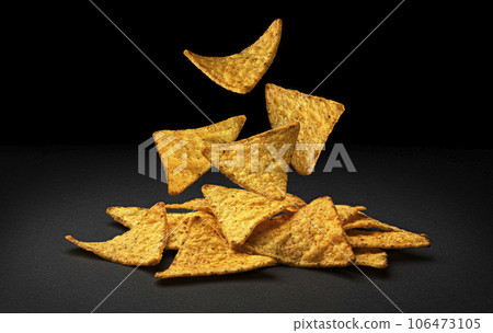 Falling corn chips, hot Mexican nachos isolated on black background 106473105