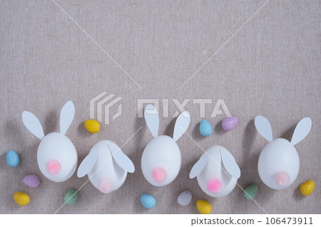 Banner with white eggshell bunnies and chocolate eggs on fabric background. Horizontal, place for your text. 106473911