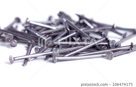 Pile of small grey metal nails isolated on white background. Close-up 106474175