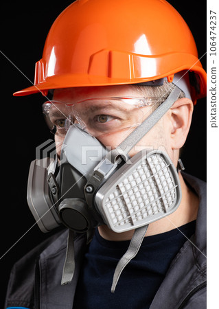 A man wearing a helmet, respirator and goggles on a black background 106474237