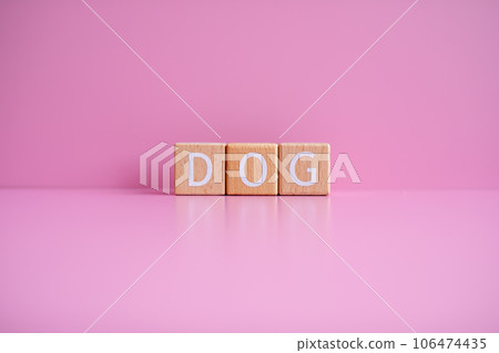 Wooden blocks form the text DOG against a pink background 106474435