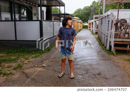 full length portrait of the child tasting the rain with the tongue full length portrait of the child tasting the rain with the tongue 106474707