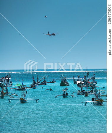 Airplane and bird flying over Jukung traditional boat in tropical sea at Bali Airplane and bird flying over Jukung traditional boat in tropical sea at Bali 106475008