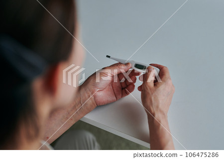 Senior woman measuring fever with a thermometer 106475286