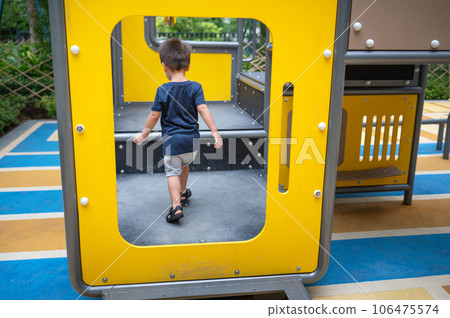 A toddler is playing on toys in the park 106475574