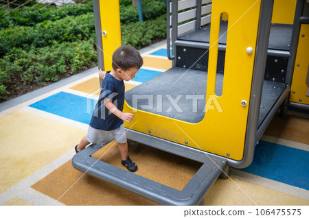 A toddler is playing on toys in the park A toddler is playing on toys in the park 106475575
