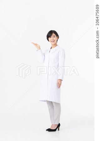 一位身穿白大褂的年輕女子站在白色背景下 106475689