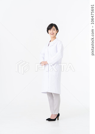 一位身穿白大褂的年輕女子站在白色背景下 一位身穿白大褂的年輕女子站在白色背景下 106475691