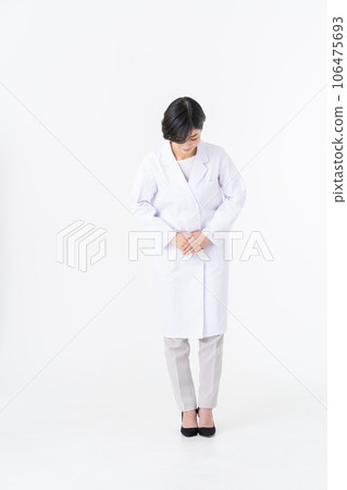 一位身穿白大褂的年輕女子站在白色背景下 一位身穿白大褂的年輕女子站在白色背景下 106475693