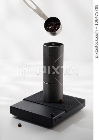Putting coffee beans into a manual coffee grinder. 106475789