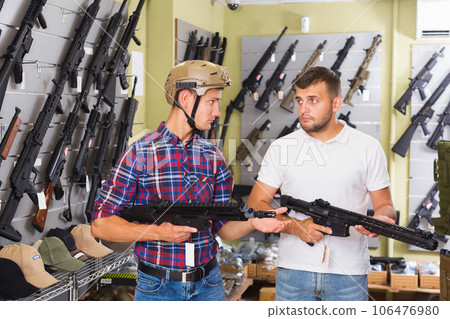 Friends choosing air-powered gun Friends choosing air-powered gun 106476980