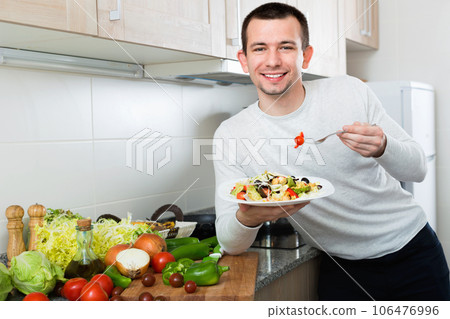 Cheerful handsome man holding plate 106476996