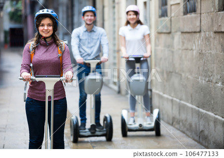 Three friends driving segways . 106477133