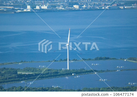 A wind turbine standing by the sea and receiving sea breeze 106477174