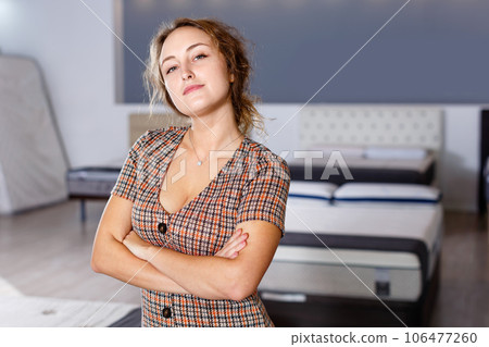Portrait of smiling attractive girl standing with arms crossed in home furnishing store 106477260