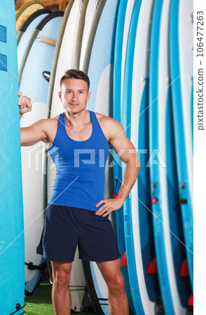 man choosing surf equipment in surf club 106477263