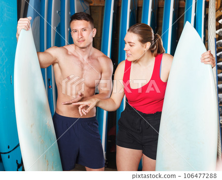Couple choosing surf equipment 106477288