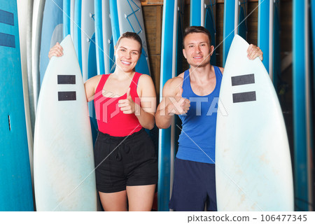 sporty couple with surf equipment in surf club 106477345