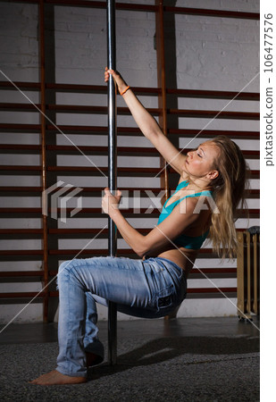Woman on pylon in lightless studio 106477576