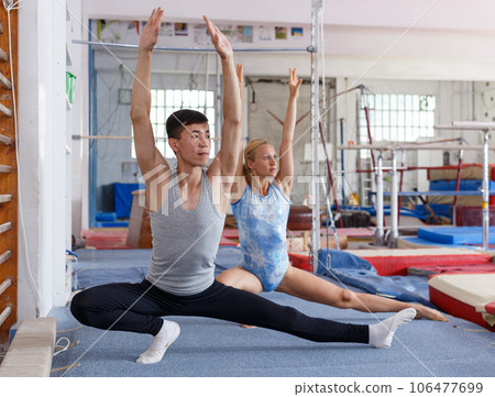 Sporty female and male acrobats during workout in sport gym Sporty female and male acrobats during workout in sport gym 106477699