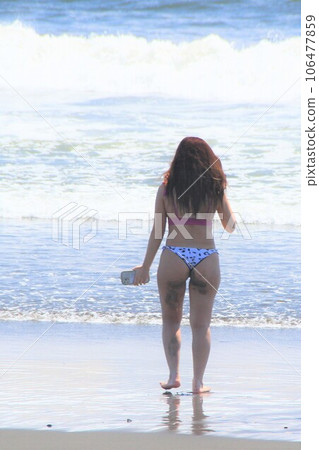 A young woman in a bikini walking along the beach Summer scenery A young woman in a bikini walking along the beach Summer scenery 106477859