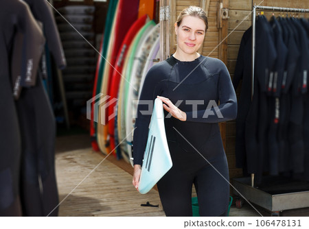 woman dressed in water suit holding surfboard woman dressed in water suit holding surfboard 106478131