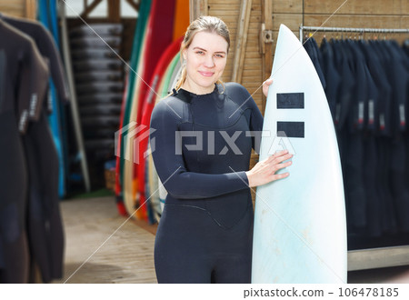 woman dressed in water suit holding surfboard woman dressed in water suit holding surfboard 106478185