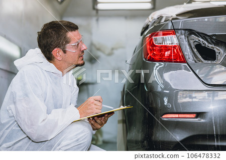 car body painter professional male worker checking color paint detail in auto garage bodywork shop car body painter professional male worker checking color paint detail in auto garage bodywork shop 106478332