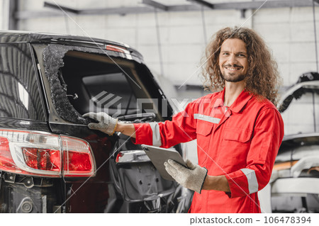 mechanic male happy smiling work insurance online claim accident car in garage auto workshop from internet tablet 106478394