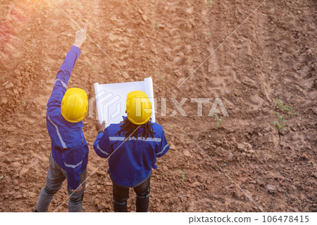 engineer land surveryor teamwork looking inspecting mark contruction site for building project with floor plan 106478415