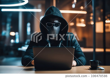 Anonymous computer hacker in mask and hoodie using laptop computer for cyber attack. Data thief 106478586