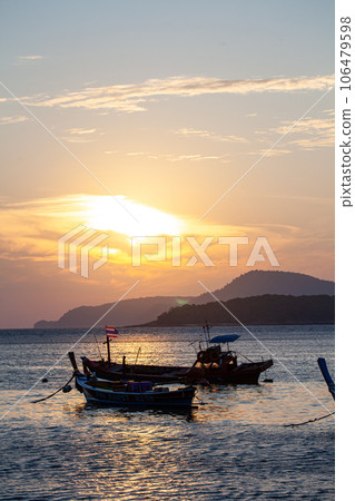 amazing yellow sky of sunrise above the island. The sunlight reflects off the particles in the atmosphere,  creating a beautiful yellow glow that is further enhanced by the horizon of the island. 106479598