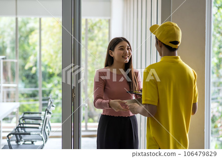 Asian woman pick up paper parcel from courier man in meeting room Asian woman pick up paper parcel from courier man in meeting room 106479829