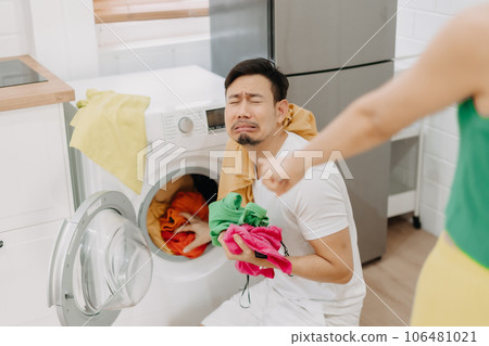 Funny man crying being force by his wife to wash clothes and do housework. 106481021