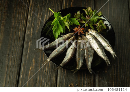 Salted anchovy with spices and herbs in an black plate. The idea of a fish diet or a delicious lunch for a street bar 106481114