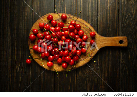 Ripe cherries on a kitchen board. A stack of cherry before sorting and cooking on the kitchen table Ripe cherries on a kitchen board. A stack of cherry before sorting and cooking on the kitchen table 106481130