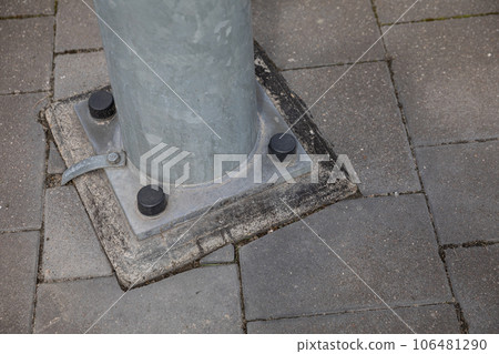 A metal lamp post attached to a concrete base. A metal lamp post attached to a concrete base. 106481290