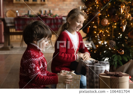 Happy curious small kids opening wrapped boxes. Happy curious small kids opening wrapped boxes. 106481704