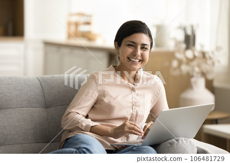 Cheerful freelance woman resting on home couch with digital gadget Cheerful freelance woman resting on home couch with digital gadget 106481729