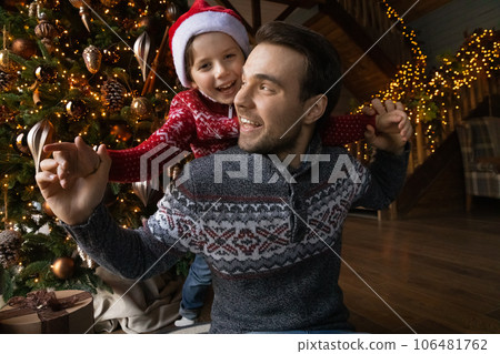 Happy young father holding on back little kid son. 106481762