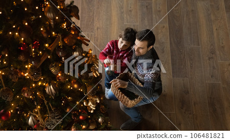 Happy young father and small son decorating Christmas tree. 106481821