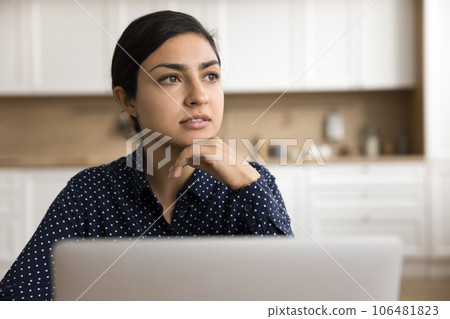 Thoughtful Indian freelancer woman sitting at laptop 106481823