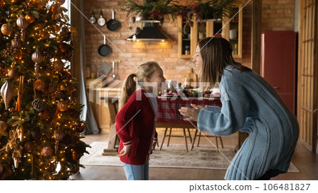 Happy young mother and little daughter dancing near Christmas tree. 106481827