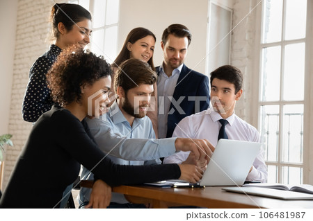 Motivated multiracial colleagues work together on laptop Motivated multiracial colleagues work together on laptop 106481987